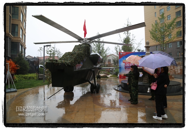 小區(qū)突然出現(xiàn)“飛機(jī)坦克”，其中殲15艦載戰(zhàn)斗機(jī)一架、99式主戰(zhàn)坦克一輛、武直-10武裝直升機(jī)一架，吸引了眾多市民雨中圍觀、合影。